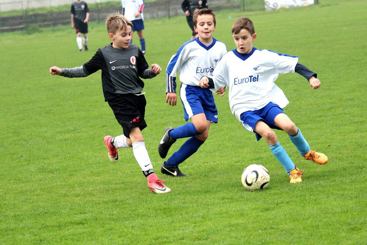 chłopcy grający w piłkę nożną na boisku